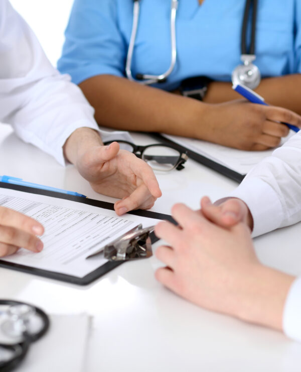 Two doctors and male patient discussing medical history